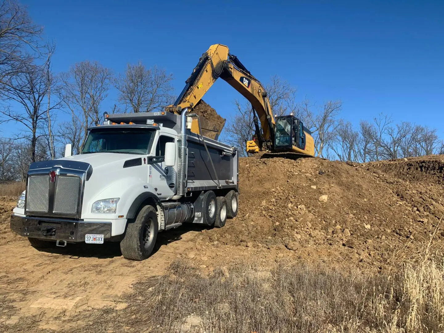 A dump truck is parked on the side of a hill.